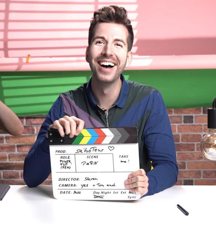 Man holding a clapperboard and smiling