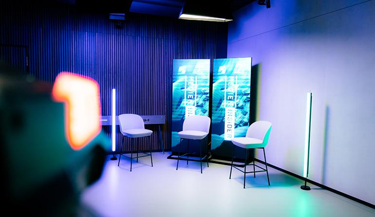 Movact.studio with two white chairs, vertical LED screens showing ocean imagery, and colorful ambient lighting.